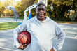 © Marko Geber - Senior man portrait with basketball smiling at outdoor court