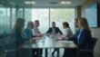 © dapra01 - A blurred view of an important management meeting taking place behind a glass wall in a modern office setting