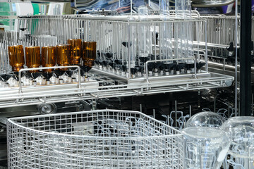 Poster - A rack of glassware is being washed in a dishwasher. The glassware includes a variety of bottles and cups, some of which have numbers on them