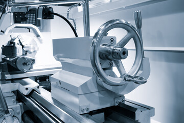Poster - A lathe machine with a white handle and a silver wheel. The handle is attached to a machine that is used to cut metal