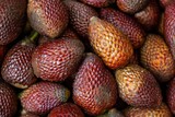 A heap of salak or snake fruit visible from above has a skin resembling snake scales