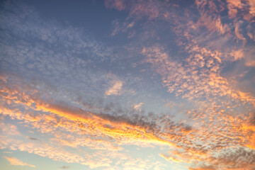 Wall Mural - a beautiful sky tinted by the sun leaving vibrant shades of gold, pink, blue and multicolored. cloud