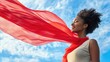 © Rodica - Joyful woman with flowing red scarf against a blue sky backdrop