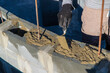 © yanadjan - Male craftsman pouring concrete into concrete bricks. Selective focus.