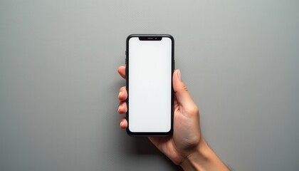 Poster - Minimalist hand holding a blank smartphone against a neutral gray background during daytime