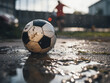 © Llama-World-studio - Soccer ball resting near a puddle outdoors with space for adding text