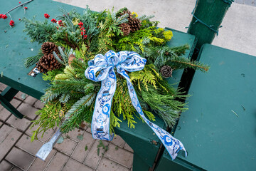 Handmade Christmas wreath made of fresh cut evergreen boughs, red berries, pinecones, and festive ribbon and bow, celebrate the holidays with hand crafted décor
