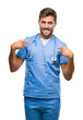 © Krakenimages.com - Young handsome doctor surgeon man over isolated background looking confident with smile on face, pointing oneself with fingers proud and happy.