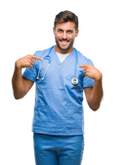 Wall Mural - Young handsome doctor surgeon man over isolated background looking confident with smile on face, pointing oneself with fingers proud and happy.