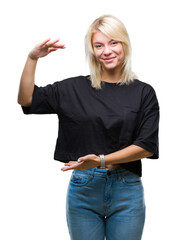 Wall Mural - Young beautiful blonde woman over isolated background gesturing with hands showing big and large size sign, measure symbol. Smiling looking at the camera. Measuring concept.