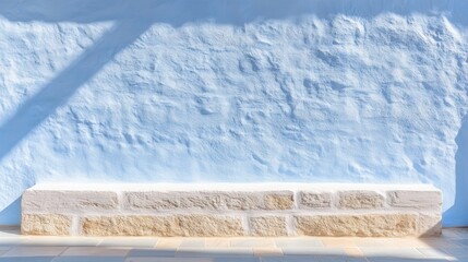 Sunlit minimalist blue wall with stone base