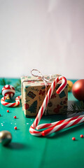 Aufkleber - Beautiful Christmas vertical background with a wrapped gift, candy canes, and festive decorations on a green surface