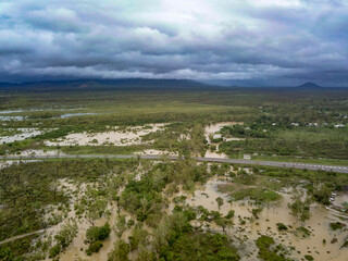 Aerial view of flooded town and river with brown floodwater, Townsville, Queensland