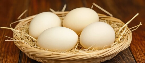 Poster - Fresh chicken eggs nestled in a straw-lined basket on a wooden kitchen table with space for text or branding.