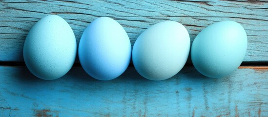 Poster - Pastel blue Easter eggs arranged on a rustic wooden table creating a serene and festive atmosphere for spring celebrations.