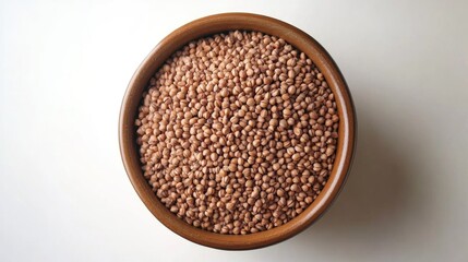 Aufkleber - Bowl of uncooked buckwheat grains isolated on a white background viewed from above showcasing healthy grain options for cooking