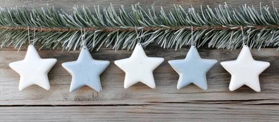 Poster - Homemade cold porcelain Christmas star garland with spruce branches on a rustic burnt wood background top view design