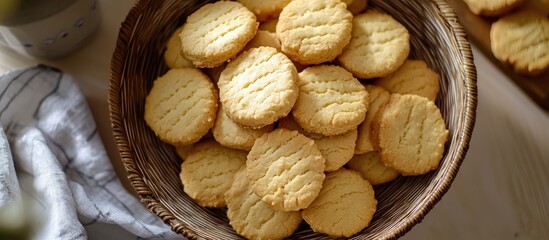 Canvas Print - Homemade butter cookies arranged in a woven basket on a rustic table showcasing a delicious and inviting dessert spread