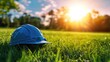 © Seyyar - Industrial safety helmet lying on green grass field under sunset with vintage filter emphasizing outdoor safety and construction themes