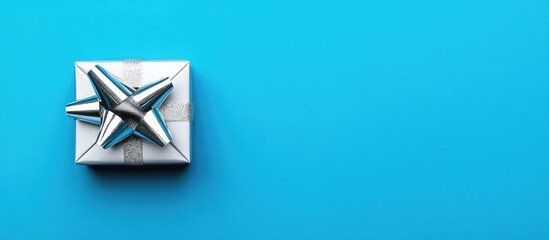 Aufkleber - Silver gift box with a decorative bow on vibrant blue background in flat lay style ideal for holiday or celebration themed promotions