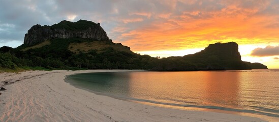Poster - breathtaking sunset over tranquil beach with rocky cliffs and vibrant sky reflecting on calm water a