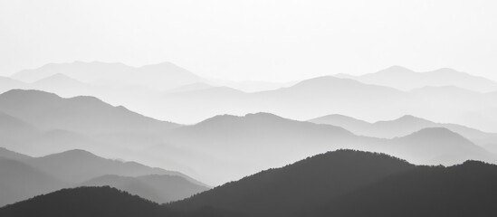 Aufkleber - Serene monochrome mountain landscape with layered peaks and soft mist creating a peaceful atmospheric effect in nature photography