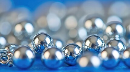 Poster - Close-up view of shiny metallic spheres on a blue background showcasing reflections and depth of field in an artistic arrangement.