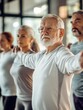 © Johannes - Group of seniors doing stretching exercise together at retirement centre. Elderly men and old women exercising at nursing home during daily fitness. Retired couples exercising at care facility.