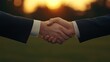 © saichon - Two hands shake in a warm sunset, symbolizing partnership, agreement, and collaboration in a professional or personal context.