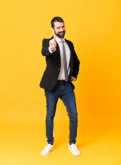 Wall Mural - Full-length shot of business man over isolated yellow background showing and lifting a finger