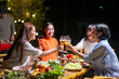 © Wasana - A group of women are gathered around a table with food and drinks