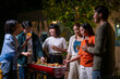 © Wasana - A group of people are gathered around a barbecue grill