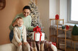 © Pixel-Shot - Young mother greeting her little daughter with Christmas at home