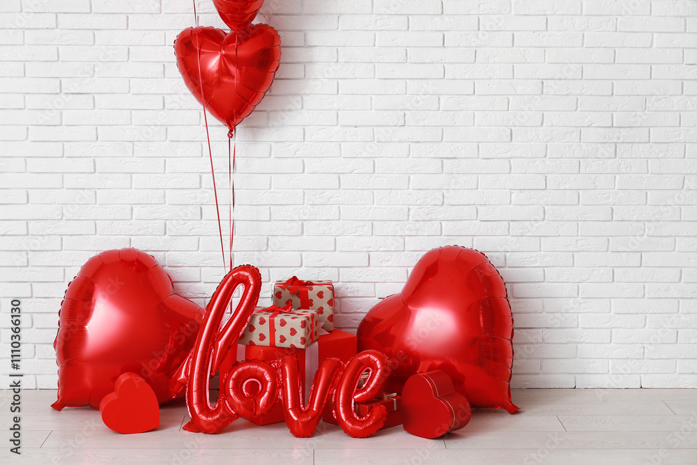 Heart shaped air balloons and gift boxes near white brick wall. Valentine's day celebration