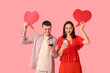 © Pixel-Shot - Young couple with mobile phones and speech bubbles on pink background. Online dating