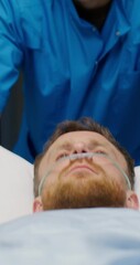 Wall Mural - An orderly carries a patient with an oxygen tube in his nose on a trolley along the hospital corridor