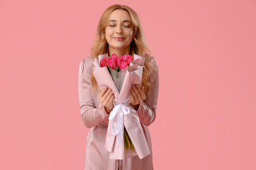 Wall Mural - Portrait of beautiful middle-aged woman with bouquet of flowers on pink background. International Women's Day