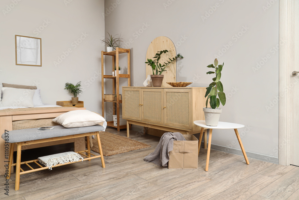 Interior of bedroom with soft bench, shelf unit and plants