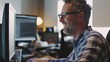 © Viktoriia - Happy Professional: A man with a satisfied smile while working on his computer, highlighting his enjoyment of his work.