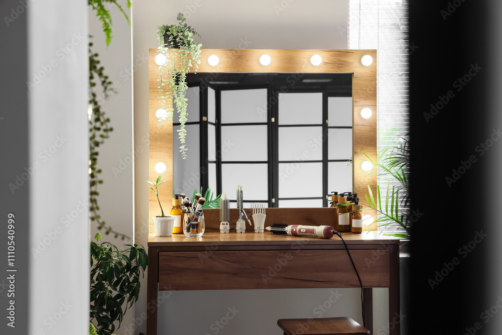 Makeup table with cosmetics and hair styler in dressing room