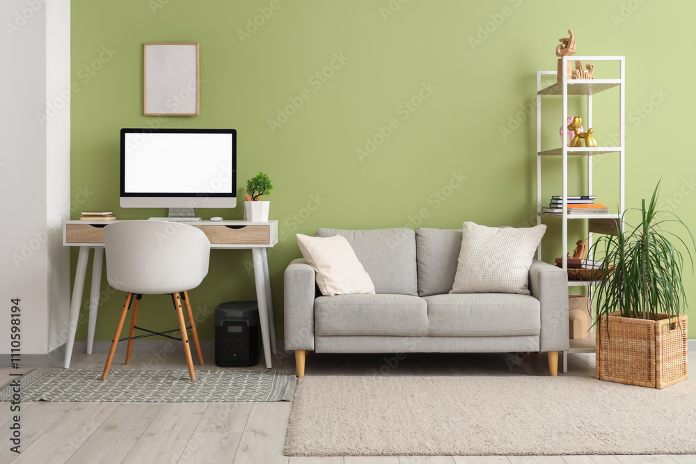 Interior of living room with workplace, shelf unit and sofa