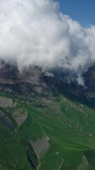Wall Mural - aerial view on caucasus mountains under epic moving clouds, kabardino-balkaria, russia. vertical vid