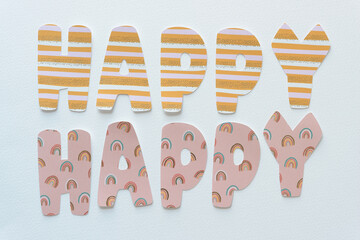 Sticker - paper sign composed of machine-cut paper letters arranged to say: happy, happy