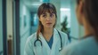 © Tahir AI - A young female doctor engaged in a conversation with a colleague in the hallway.