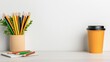 © niramol - A photostock of a cheerful workspace setup with colored pencils, a notebook, and a coffee cup on a clean wooden desk. High Quality