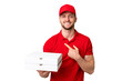© luismolinero - Pizza delivery man with work uniform picking up pizza boxes over isolated chroma key background pointing to the side to present a product