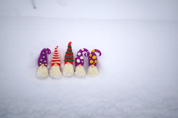 Wall Mural - Small toy dwarfs made of plasticine on a background of snow. Christmas toys.