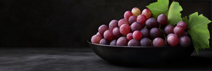 Canvas Print - Fresh grapes arranged in a decorative bowl with green leaves against a dark background