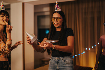 Poster - A group of friends enjoys a fun birthday celebration at home, wearing party hats and sharing laughter. The cozy atmosphere and festive mood create a joyful experience.