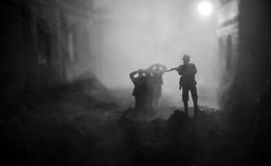 Wall Mural - Military silhouettes fighting scene on war fog sky background. A German soldiers raised arms to surrender. Plastic toy soldiers with guns taking prisoner the enemy soldier.